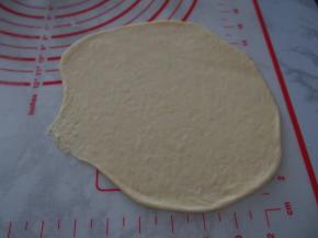 将面团擀成牛舌状，末端收口处压薄