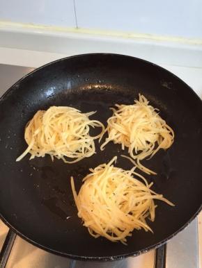 热油锅，然后拿适量土豆丝放进锅内，适当用铲子压一下