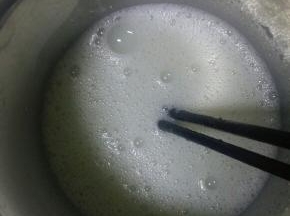 先把容器放入锅中开水煮沸消毒，然后沥干水份，把白糖全部倒入消毒过的容器中，再倒入少量的牛奶，搅拌，直到白糖全部融化