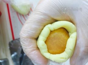 包入金丝肉松馅，用虎口慢慢往上推，包裹住月饼馅料