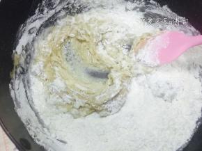 中筋面粉和小苏打过筛加入糖油混合物中，再加入水，搅拌均匀成团