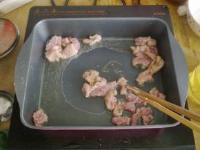 锅里倒入油，把肉放入煎炸至表面金黄。