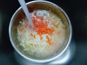 插好的胡萝卜丝和土豆丝放入大口器具中，用冷水冲洗。