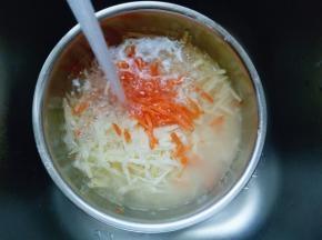 插好的胡萝卜丝和土豆丝放入大口器具中，用冷水冲洗。