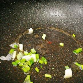 锅中余油加热，爆香葱段，