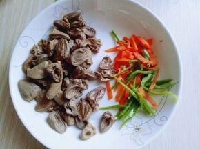鸡心:首先把鸡心头切掉，再将鸡心一切二，依次做完，之后将鸡心焯水，水烧开后加入一切二的鸡心，大火约2分钟，捞出用冷水冲洗干净。
胡萝卜去皮洗干净切丝，青椒洗干净切丝。蒜去皮切碎。