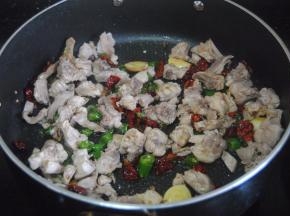 倒入兔肉快速翻匀中火翻炒至肉稍变干