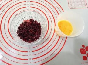 先来制作馅料。蔓越莓切碎，鸡蛋打散，称好所需蛋液。