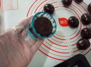 50克月饼模具安装好，把圆球搓成椭圆状放入模具中，把四周按平，模具里不用撒粉。