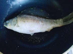 平底不粘锅中加入油，放入洗干净的鱼，中小火剪至两面微黄。