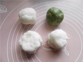 带上手套，将月饼面团平均分成4份，取其中1份面团加青汁粉，揉匀成小球。