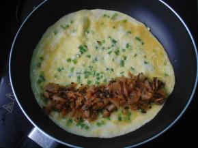 煎得蛋液差不多全凝固时放入一半拌好的辣白菜