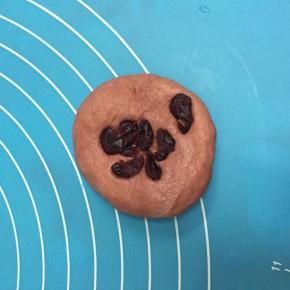 取一红色面团，加入少量蔓越莓，揉圆。