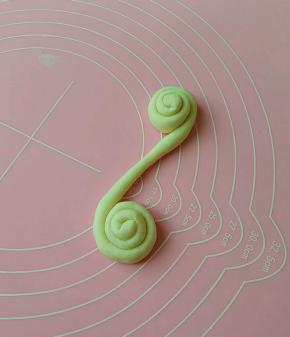 搓成长条，朝两头卷起来。