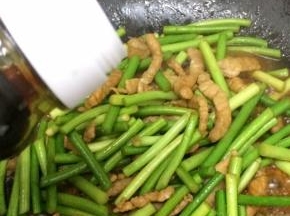 再倒入少许的生抽翻炒，直到蒜苔变软