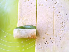 取一个奇异果放在一片蛋糕片上卷起来，顺着奇异果的圆弧卷紧