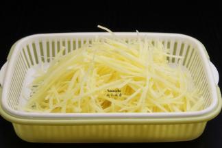 捞出土豆丝，沥干水，放入孜然粉、盐腌制出水；