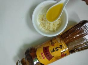 大蒜装入碗里，加入一勺金龙鱼菜籽油。