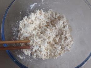 用手和成面团，刚开始和的时候比较粗糙，将盆子倒扣盖着面团，静置5-10分钟