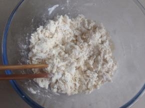 用手和成面团，刚开始和的时候比较粗糙，将盆子倒扣盖着面团，静置5-10分钟