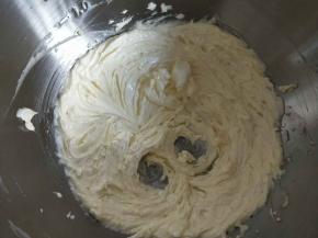 将牛奶加入黄油中继续打发至羽毛状。