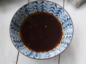 磨好的蒜蓉倒入一小勺凉白开水，陈醋、盐和少许卤千张的汁，再加香油和油泼辣子调匀后就成这么一小碗调料。