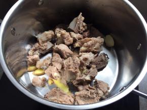 生姜、蒜、猪骨，放入煮锅中；