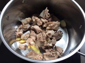 生姜、蒜、猪骨，放入煮锅中；