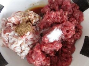 把剁好的肉馅放入盆里，放入盐、五香粉、胡椒粉、黄酒、生抽，顺一个发现搅拌至上劲儿