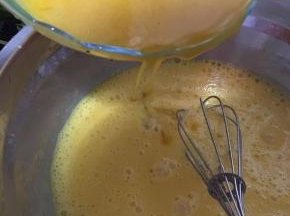 把冷却好的百香果汁慢慢倒入蛋黄，边倒边搅拌。