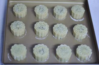 11、用力按手柄压出花纹、然后提起 花纹漂亮、纹路清晰，入炉前给月饼上方20cm处喷一些水，烤箱上下火200预热10分钟，烤5分钟，