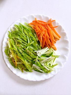 尖椒去蒂清洗干净后切成丝，胡萝卜削皮洗净切成丝，小葱切成段儿备用！