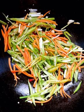 倒入切好的尖椒丝，胡萝卜丝，葱段翻炒均匀！