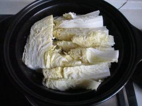 把白菜铺到锅底。