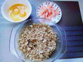 准备食材，将剩米饭倒入大口的玻璃容器里，加入生抽，老抽拌均匀。 鸡蛋敲碗里，加入十三香，用筷子打散，虾仁洗干净切小块，料酒腌制10分钟。