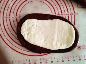 10.	取一份麻糬面团放在可可面团上，擀成稍小的椭圆形