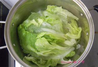 煮锅里冒小泡后放入一点食盐，放入洗干净的生菜烫软；