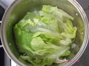 煮锅里冒小泡后放入一点食盐，放入洗干净的生菜烫软；