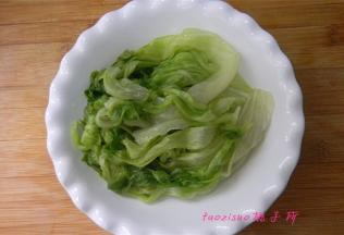 捞出过凉水的生菜，控干水份，摆在盘子里；