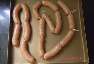 灌好的香肠一段一段系上线绳分隔开，用针在每节香肠上扎一扎，排气；