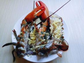 把洗干净的龙虾摆放在盘子里，撒上切碎的姜和蒜。