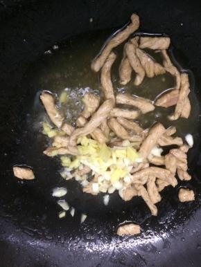 在加入生姜和大蒜粒，翻炒均匀