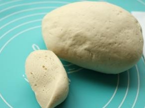 发酵好的面团移到揉面垫上，揉入60克面粉，开始揉面大约10分钟。最后面团变光滑，切面也很细腻，干面也全部揉进去了。