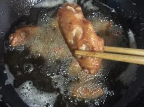 鸡翅中炸至表面呈金黄色即可捞出沥干油分备用！