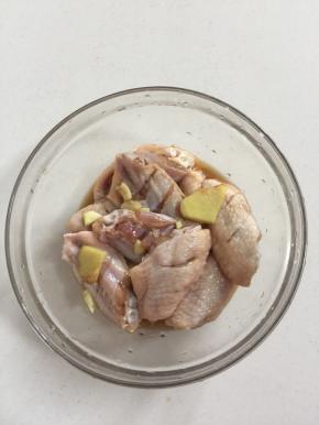 鸡翅中放入碗中加入料酒，生抽，玉米淀粉，盐，生姜，蒜瓣抓匀腌制30分钟！（也可以提前一晚上腌制好了放在冰箱冷藏保存，这样鸡翅中更入味儿！）