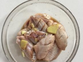 鸡翅中放入碗中加入料酒，生抽，玉米淀粉，盐，生姜，蒜瓣抓匀腌制30分钟！（也可以提前一晚上腌制好了放在冰箱冷藏保存，这样鸡翅中更入味儿！）