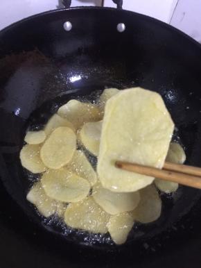 炸至土豆片熟了，表皮有点儿焦脆即可捞出沥干油分备用！
