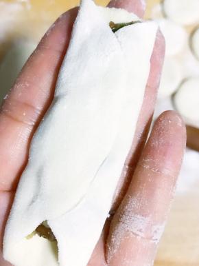 14.将边对折，包住馅，口朝下放到案板上