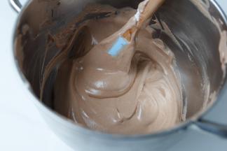 9 取一勺蛋糕糊倒入可可液里，这个部分就是为了混合可可液的，不用担心消泡的问题，快速拌匀就好。
再倒回蛋糕糊里，用抹刀翻拌和切拌的手法快速拌匀
整理下抹刀上带的蛋糕糊，刮到盆里，拌匀。