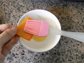 用硅胶刷沾些黄油，依次刷在南瓜片上，不用很多，薄薄一层即可。